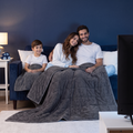 Famille sur le canapé sous les couvertures lestées parents et enfant